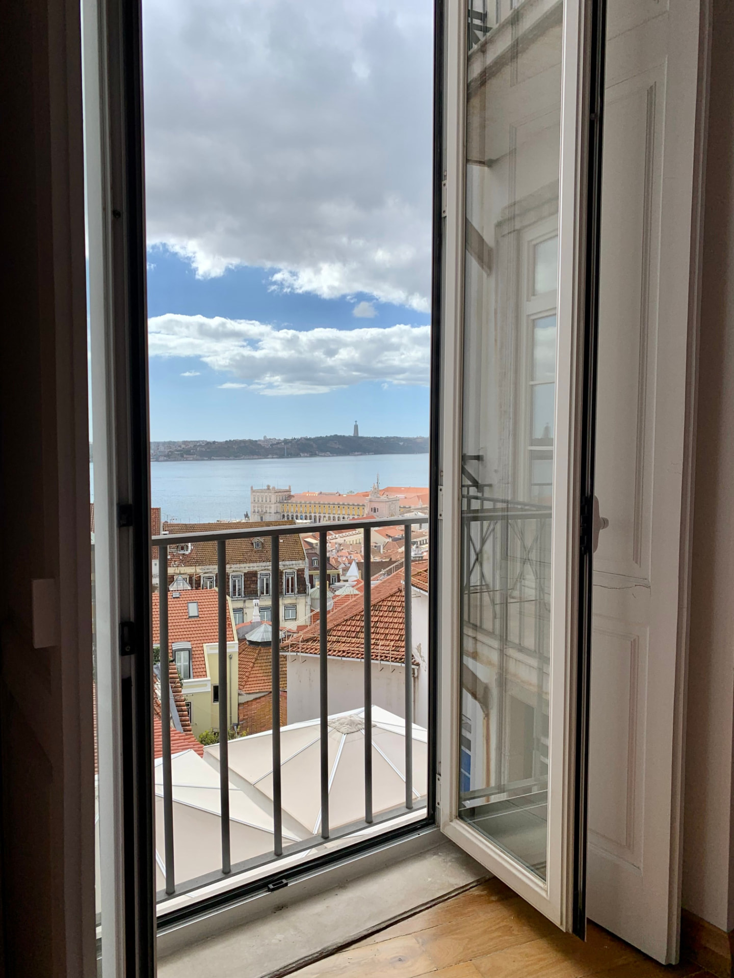Open apartment window overlooking Porto rooftops and the river